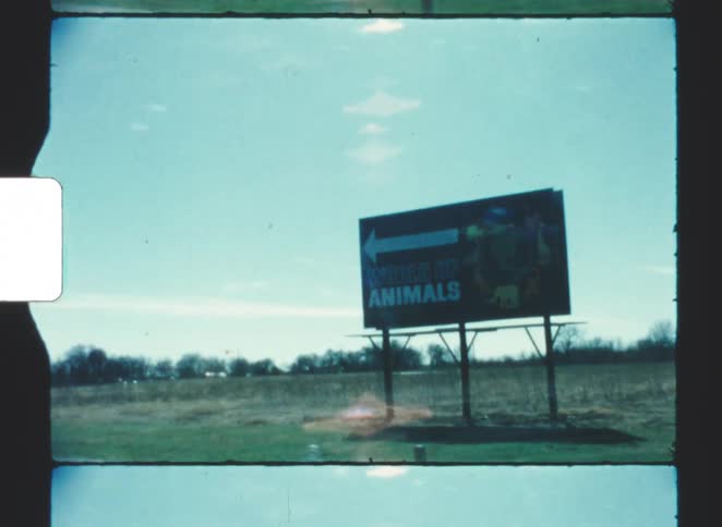 A large billboard on the side of the road gives directions