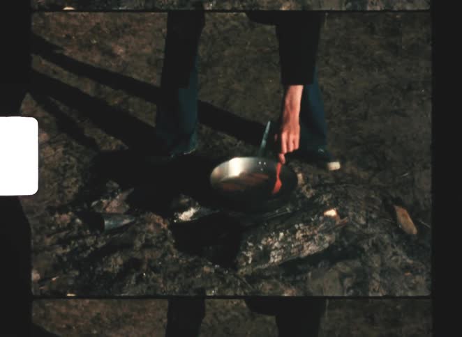 A person cooking on a campfire