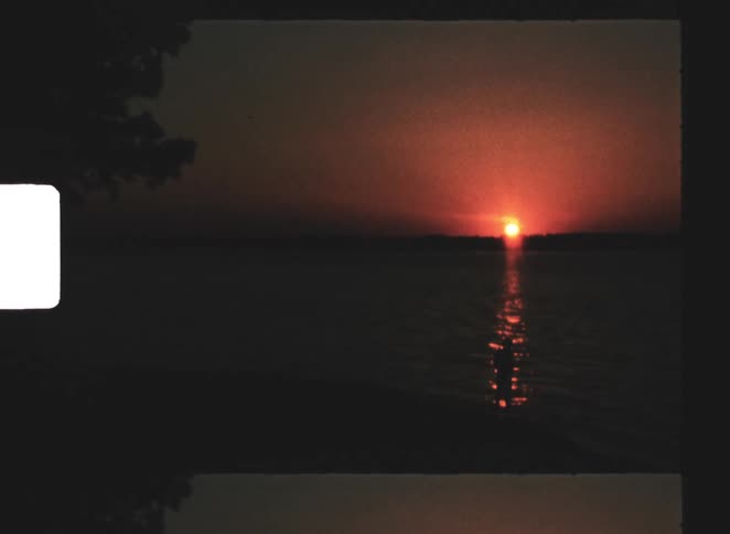 Sun low on the horizon reflects across the water at dusk