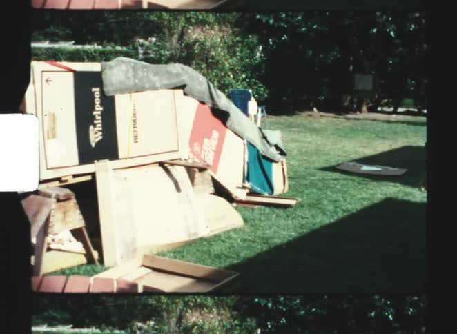 A fort made of cardboard boxes in a backyard