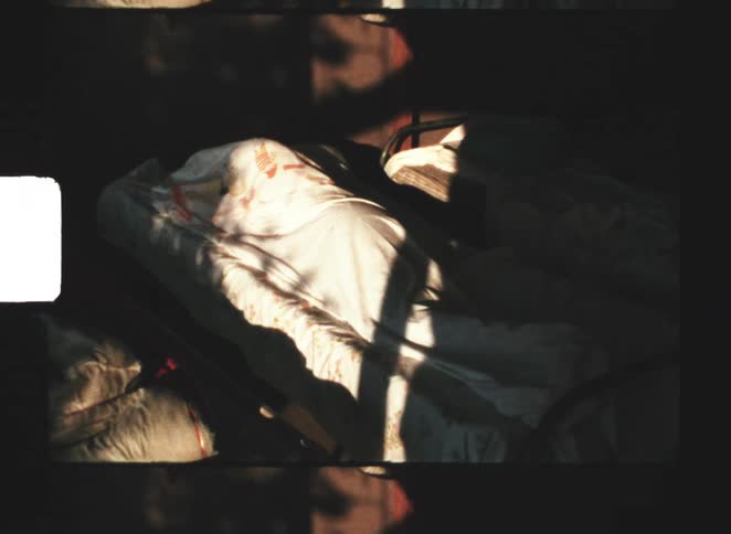 A woman laying in a bed crawling under the covers