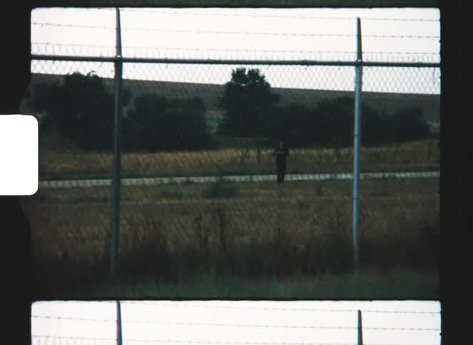 A person standing near a fence