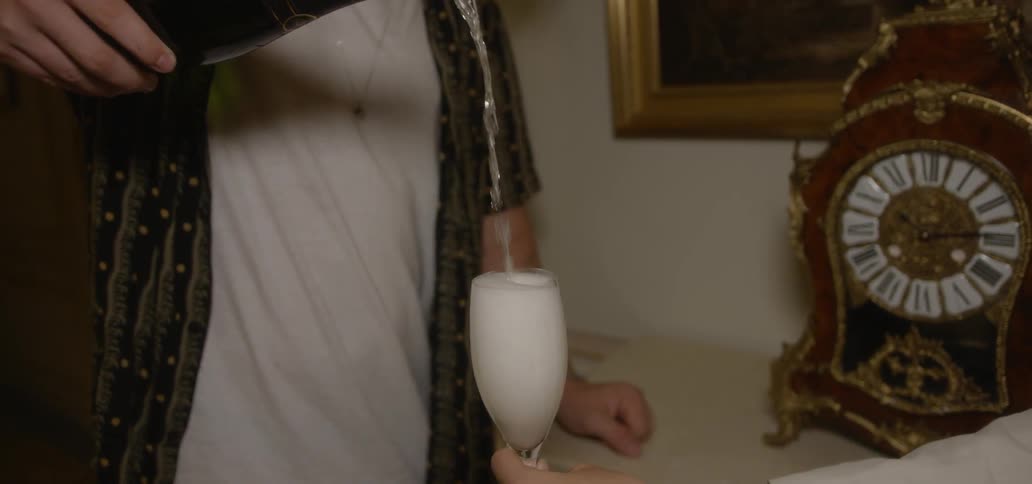 Man pouring champagne into champagne flute glass