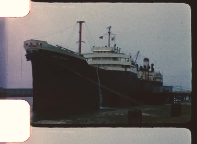 A large freight ship is docked at the pier