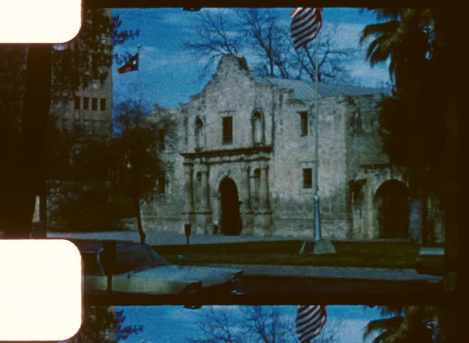 Flags are in front of the stone building