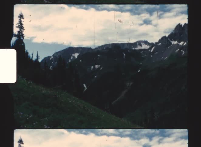 A view of a mountain range with grass on it