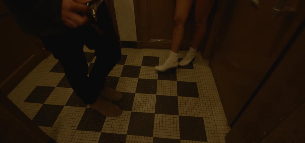 A man and woman stand on tiled floor