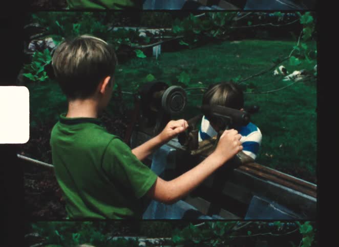 Two two boys spin a wheel on a machine
