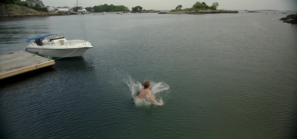 A man running down a dock and jumping into a body of water