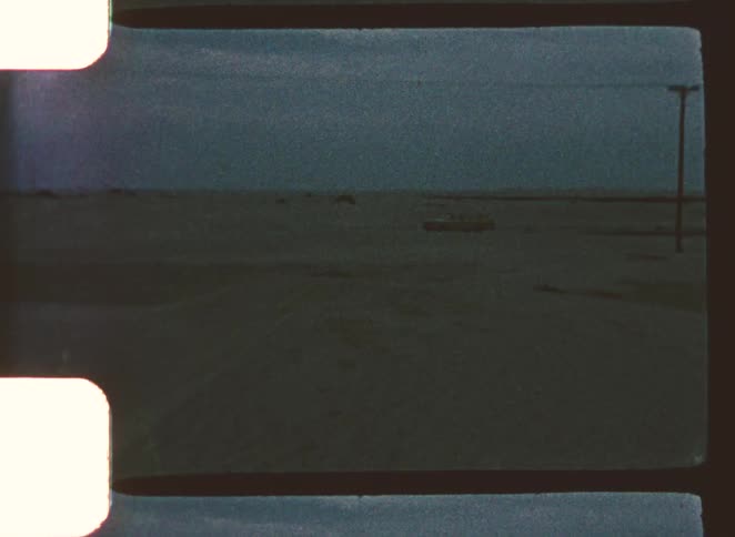 Motor vehicle sits parked on a desert highway after dusk