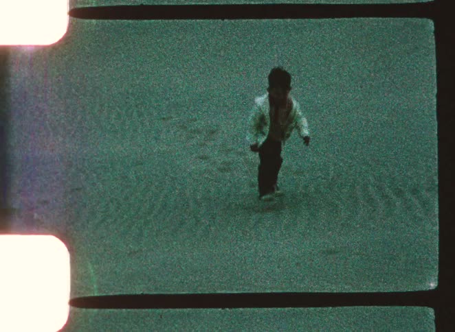 A woman and child playing in the sand at the beach