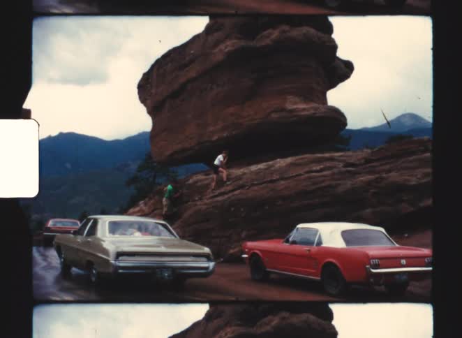 Cars driving near some large rocks