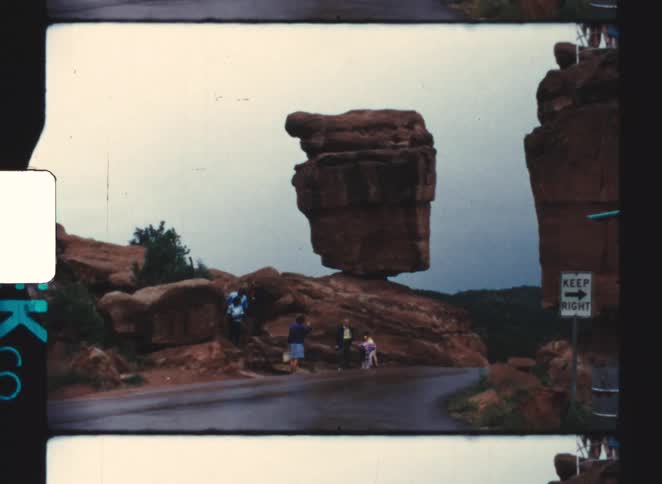 Tourists walk past the large boulders