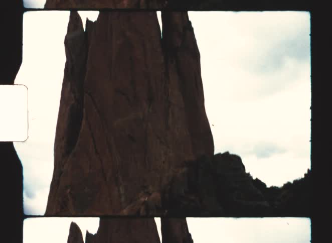 Vertical rock formation standing out against a clear sky in a natural landscape