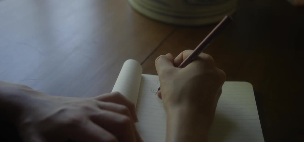 A woman is writing in a notebook