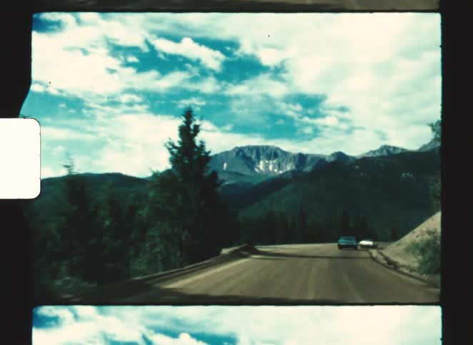 A view of cars driving down a dirt road