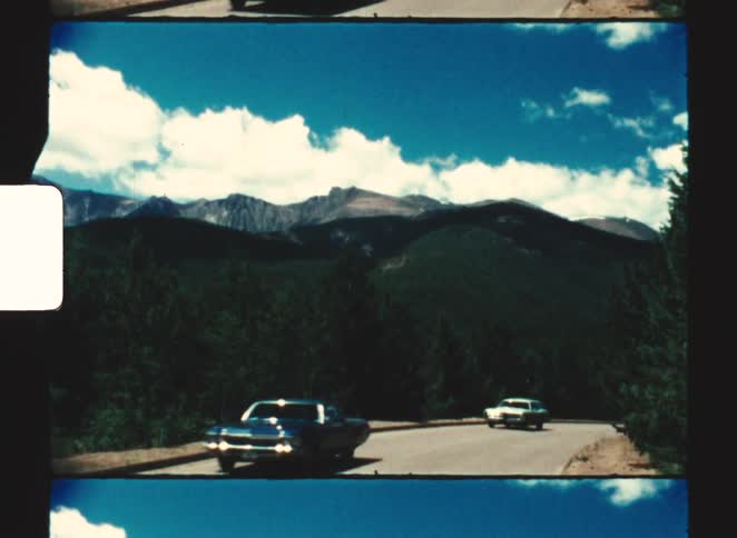 Some cars driving up a road