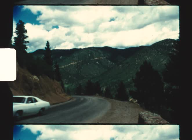 The car turns on the mountain road on a cloudy day