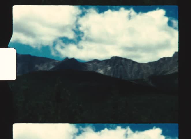 Mountain range under a blue sky with white clouds in a natural landscape