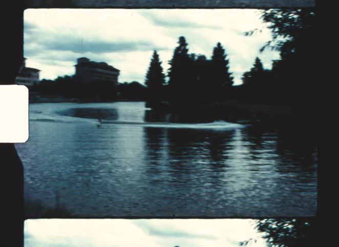 in front of the broadmoor hotel in 1970 Person being pulled by a rope across a lake with buildings in the background