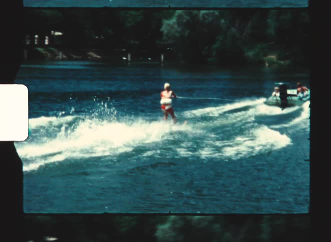 The woman is water skiing behind the boat
