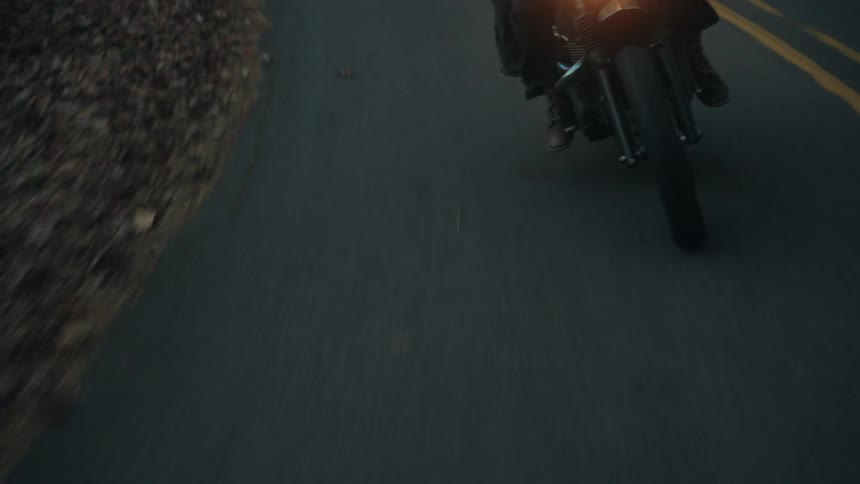 A person riding a motorcycle down a road
