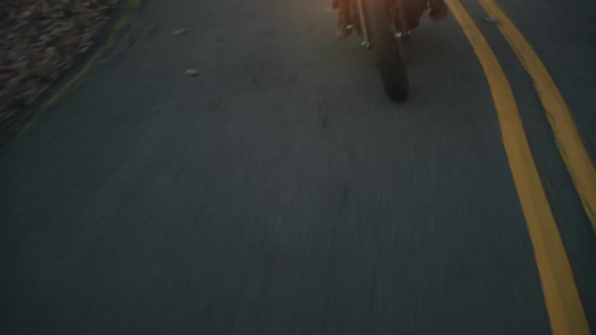 Two people ride on the motorcycle on the winding road