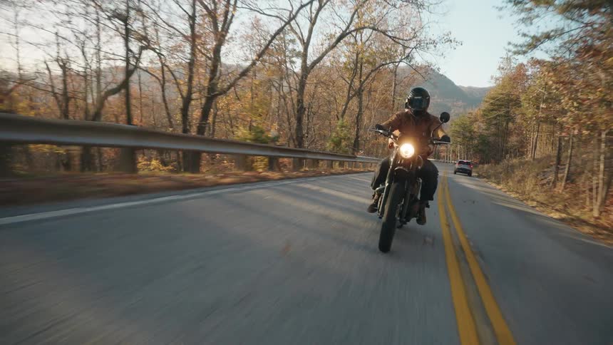 The man rides his motorcycle on the highway on a sunny day