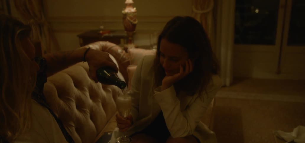 A man pours a glass of champagne for a woman