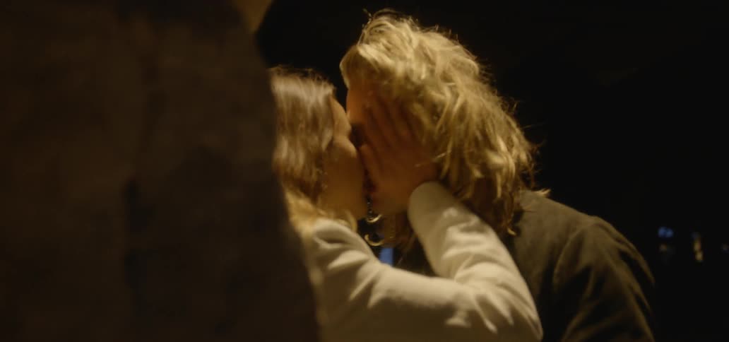 Man and woman kiss outside at night