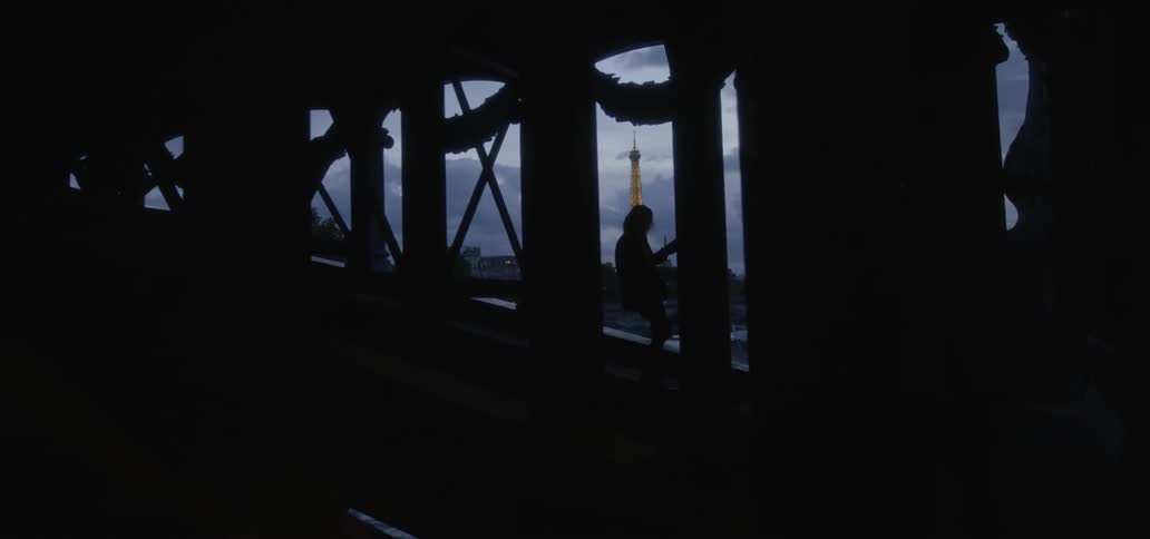 Person walks among pillars at night