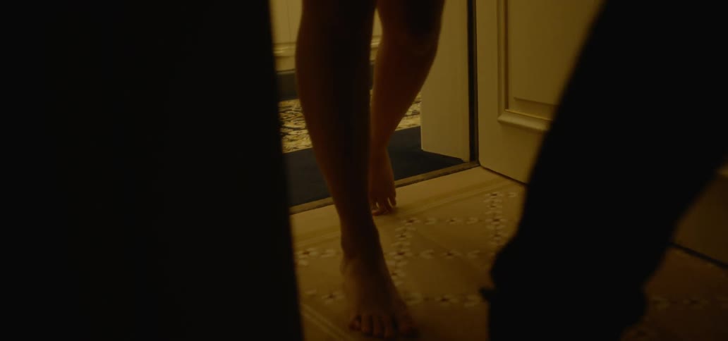 Two people open hotel room door and walk into room