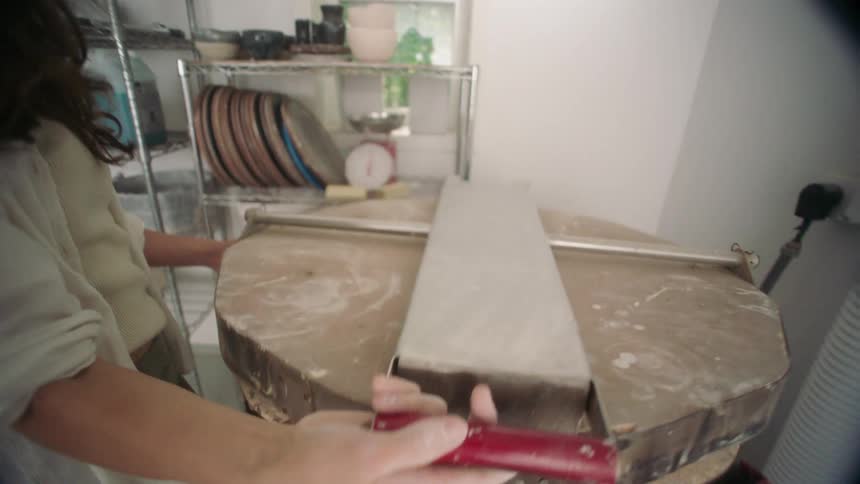 Person closing the lid of a ceramic kiln in a studio