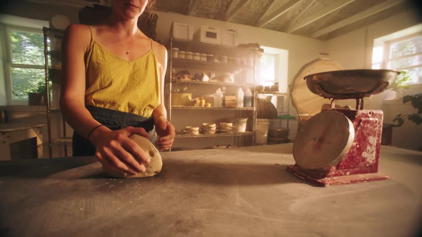 The woman is kneading dough in her kitchen