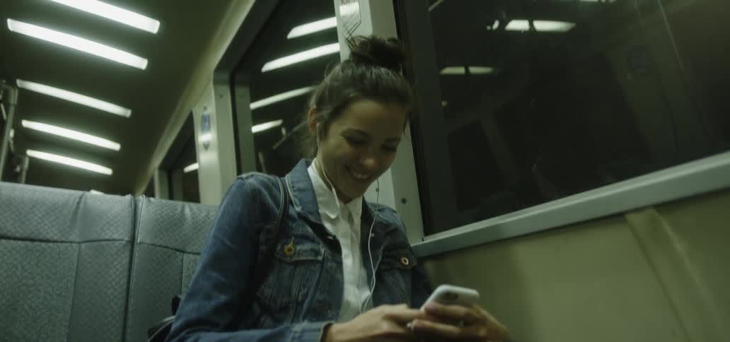 A woman uses her phone while riding the subway