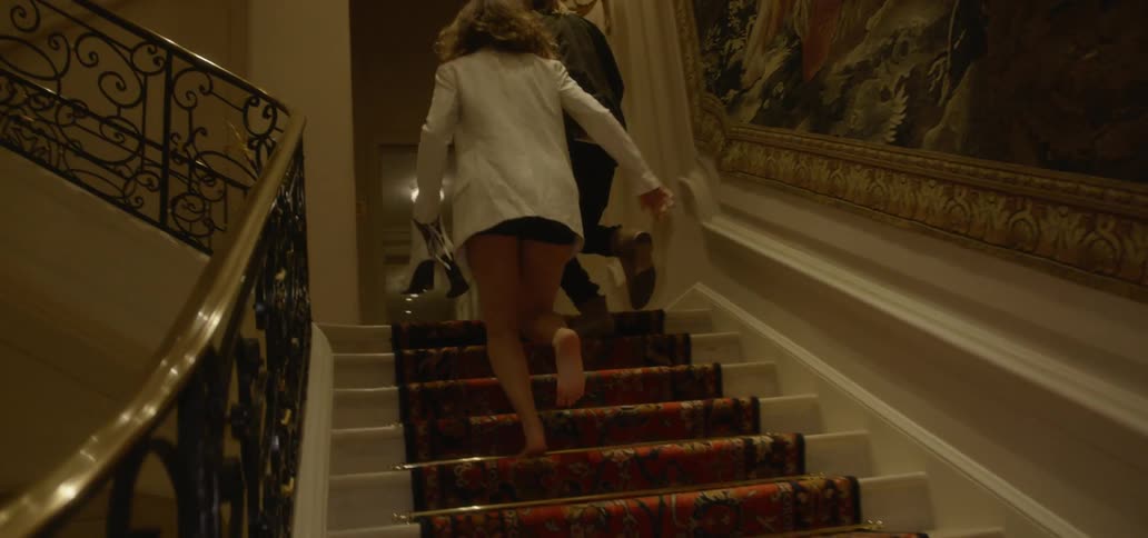 A man and woman run up a staircase