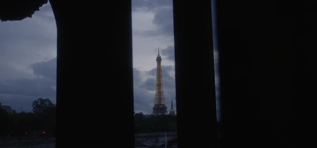 The sun is setting behind the lighted tower