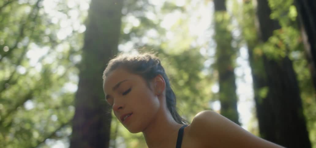 A woman is standing in the woods