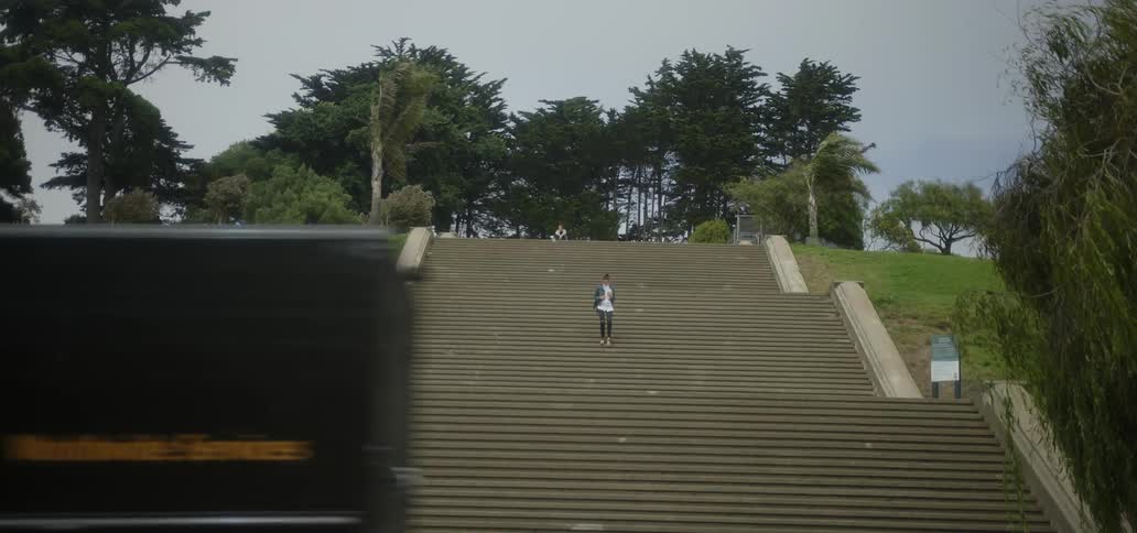 A woman walks down a large set of outdoor stairs