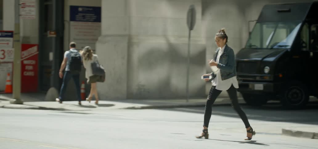 A woman crosses a city street
