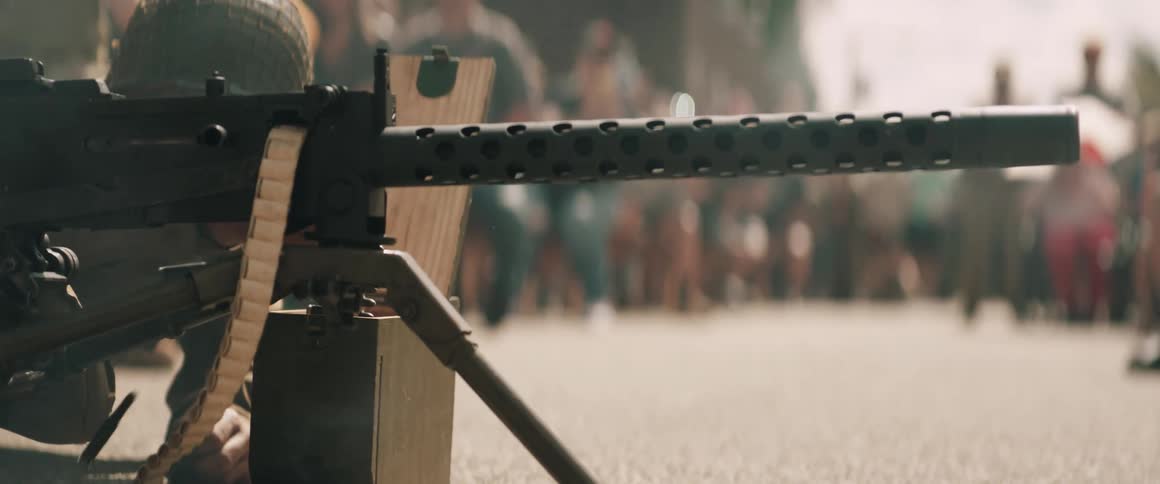Mounted machine gun with visible ammo belt and helmeted person in public setting