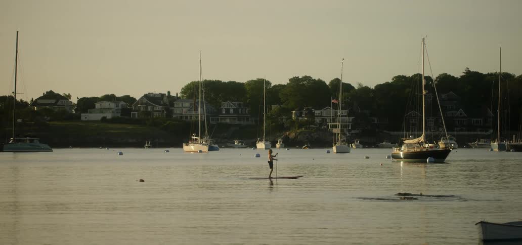 A man rows himself on a board in the water