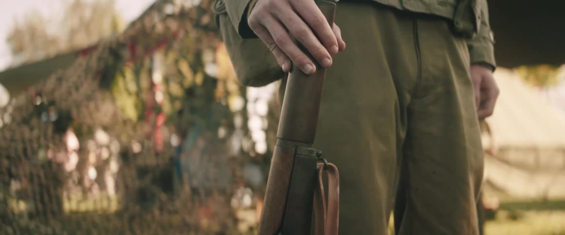 Soldier in military uniform holding rifle vertically