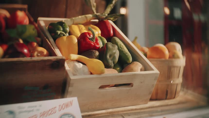 Produce in boxes and in a basket on a store counter