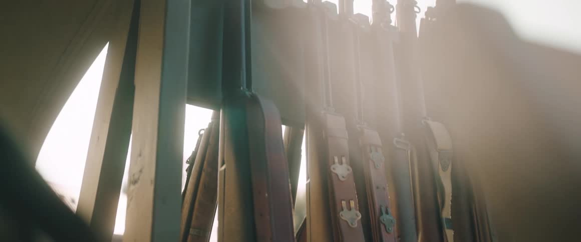 Firearms stand in a wooden frame on a sunny winter day