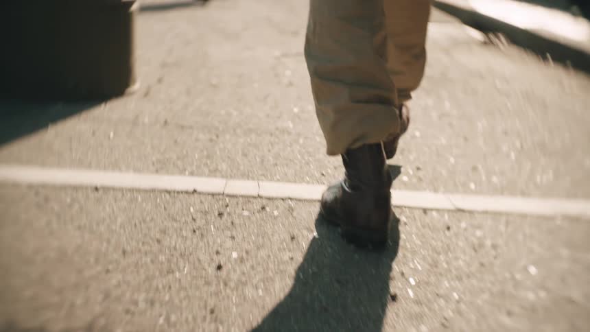 A close up of a solider walking outdoors