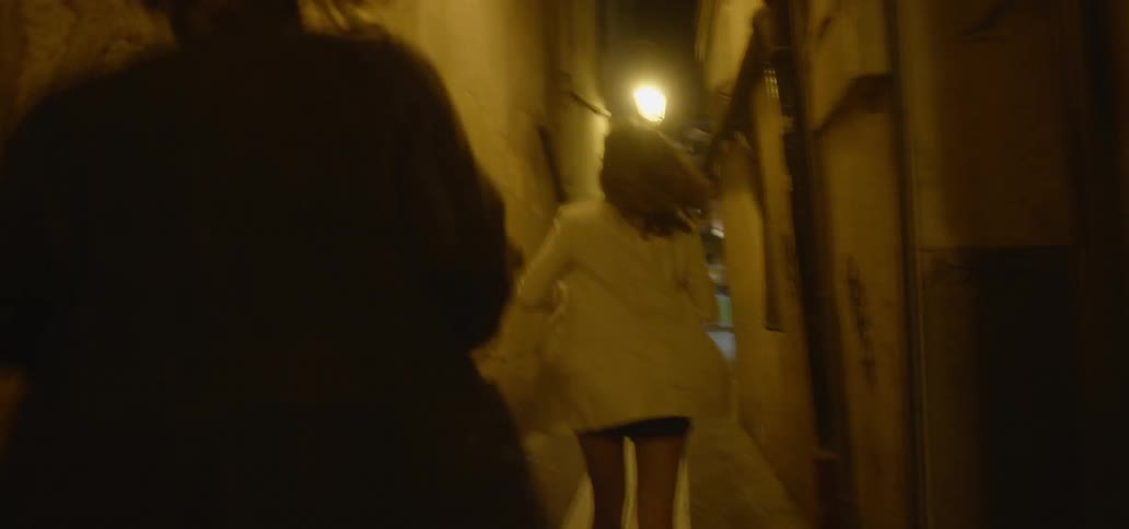 A man and woman run down an alley at night