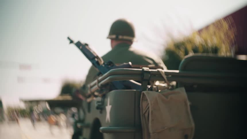 Soldier equipped in vintage vehicle with white star and sidemounted rifle