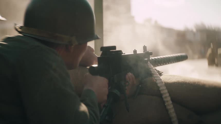 Soldier operating mounted machine gun behind sandbags in urban environment