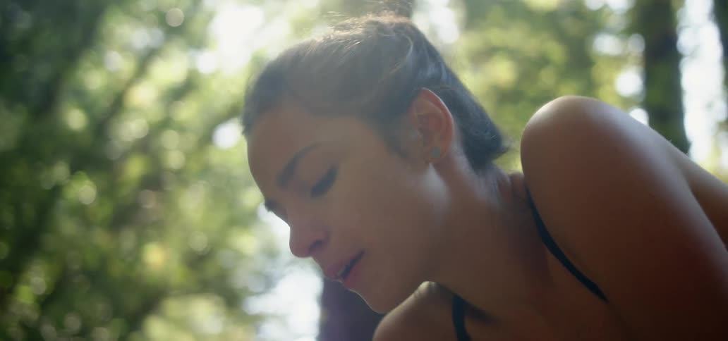 A woman is leaning forward in the forest